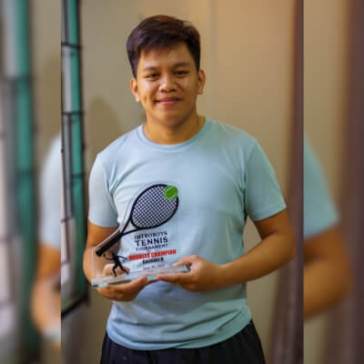 Coach Geo holding his "Introboys" tennis cup