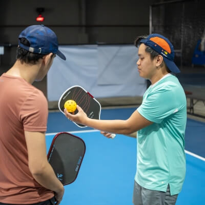 Coach Geo explaining how to hit the pickleball ball