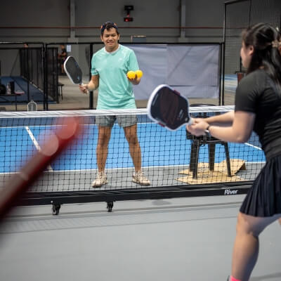 Cebu Pickleball Coach teaching female student how to play pickleball for the first time