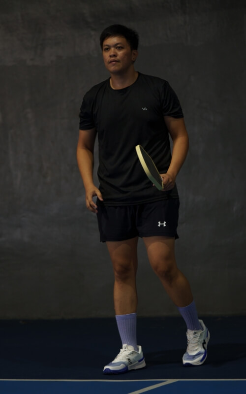 Coach Jeve portrait shot in the court atheltic stand
